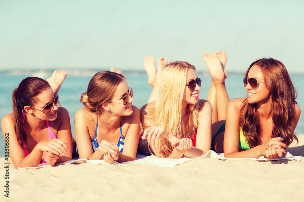 Poster group of smiling women in sunglasses on beach