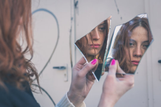 Beautiful girl looking at herself in a mirror