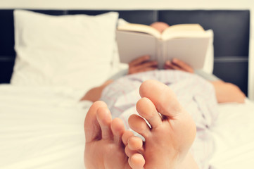 young man reading a book in bed