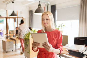 happy creative female office worker with tablet pc