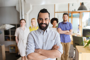 happy young man over creative team in office