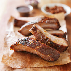 grilled barbecued ribs cut into pieces on wooden cutting board