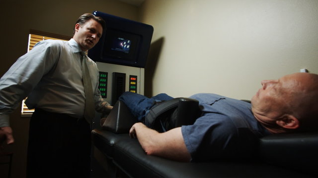 chiropractor with a patient on a machine