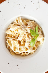 Italian pasta with sauce and parmesan cheese, served on a white 