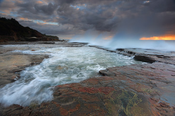 Fototapeta na wymiar Waves smash against the rocks at Coledale