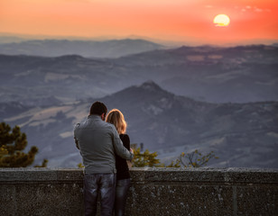 Couple hugging watching beautiful sunset