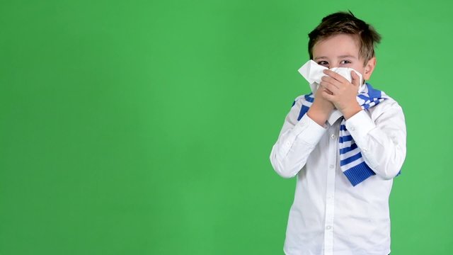 child boy blows his nose into a tissue - green screen