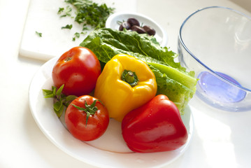 raw vegetables for salad on white plate