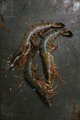 raw shrims with spice on black metal backdrop board