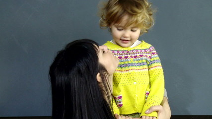 Happy mother and daughter kissing each other in love