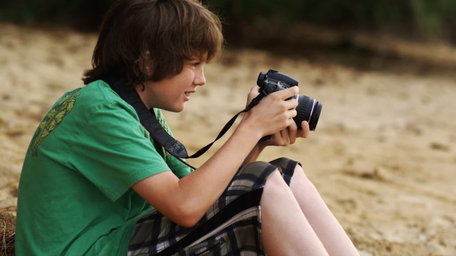 boy on the beach taking pictures