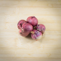 Shallots (red onion) set up on wood table