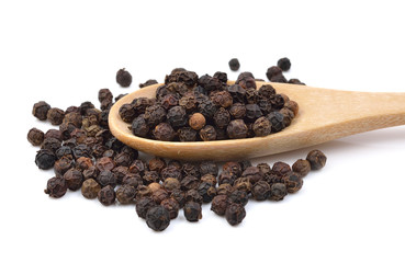 Black pepper in wooden spoon on white background.