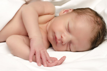 Fototapeta na wymiar Beautiful innocent newborn sleeping after bath in white sheets