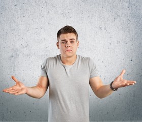 Question. Closeup portrait of dumb clueless young man, arms out