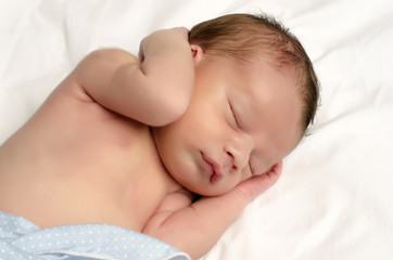 Obraz na płótnie Canvas Beautiful innocent newborn sleeping after bath in white sheets