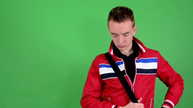 man trying on message bag and look to camera - green screen