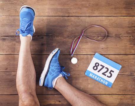 Legs of a runner on a wooden floor background