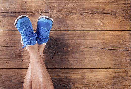 Legs of a runner on a wooden floor background