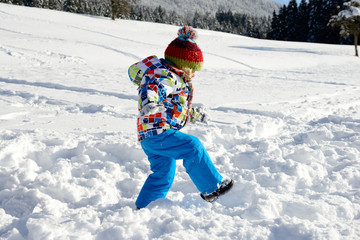 Fototapeta na wymiar little 3 year old child playing in the snow