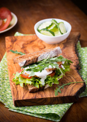 Rye toast sandwich with green leaf, tomato and chicken