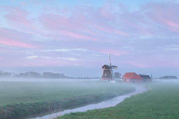 Dutch windmill in dense morning fog