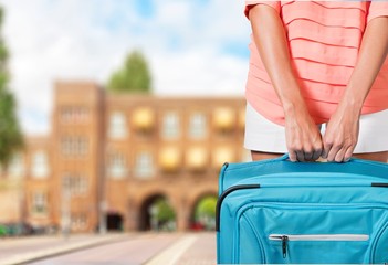Cruise. Woman in blue dress holds orange suitcase in hands on
