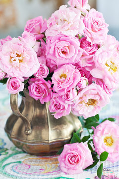Arrangement with a fresh pink roses on a table.