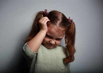 Fototapeta premium Stressed kid girl with headache holding hand the head