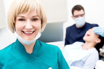 Male dentist doing teeth checkup behind