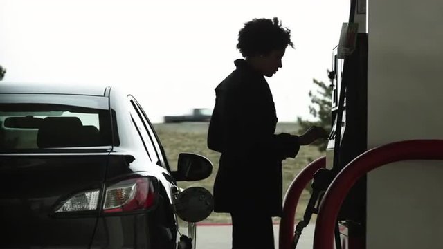 MS Woman refueling car at gas station / Orem, Utah, USA