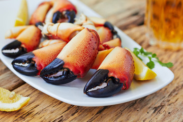Boiled crab claws on a plate and beer - obrazy, fototapety, plakaty