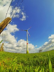 windmill in meadow producing alternative energy