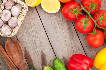 Fresh ripe vegetables and utensils on wooden table