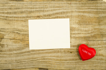 Empty card with heart on wooden table