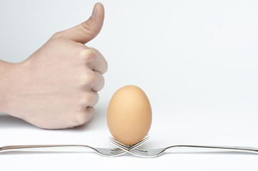 eggs on a pack and white background and hand show a like