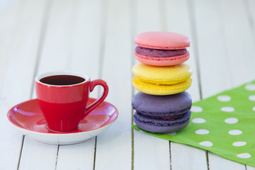 Obraz na płótnie Canvas Cup of coffee and macarons on polka dot napkin