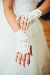 bride puts on wedding gloves