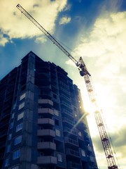 Big construction crane in the sunshine. Warm colors.
