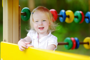Fototapeta na wymiar Toddler girl having fun at a playground