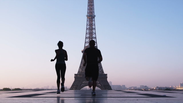 couple running towards the Eiffel tower