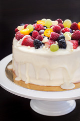 White chocolate cake decorated with fresh berries and fruits