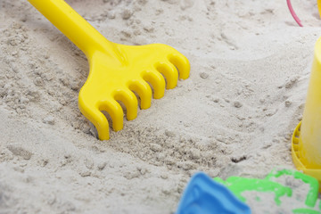 Fototapeta na wymiar Children's toy rake on the sand