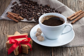 Coffee cup with gingerbread cookies, cinnamon and cane sugar