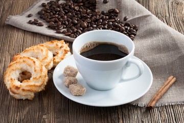 Coffee cup with coconut cookies, cinnamon and cane sugar