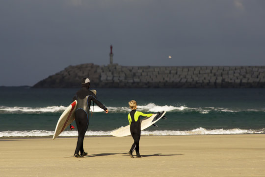 boy and man surfers waiting for the waves on Sabon beach Corunna