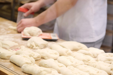Fototapeta na wymiar Chefs forming dough in order to prepare bread