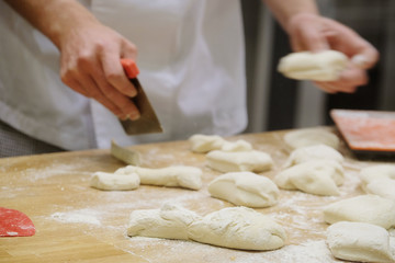 Chefs forming dough in order to prepare bread