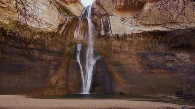 Panning medium shot of cliff wall and Lower Calf Creek Falls / Lower Calf Creek Falls, Utah, United States, 
