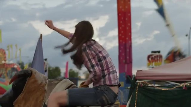 Time lapse medium shot of teenage girl riding mechanical bull at amusement park / Salt Lake City, Utah, United States